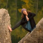 Lauren Walker in a yoga position between two boulders