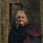 Jill Purce sitting on a stone chair