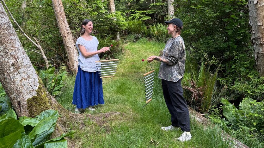 Kiko and Charlie play chimes on a forest path