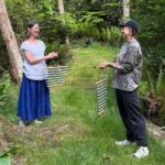 Kiko and Charlie play chimes on a forest path