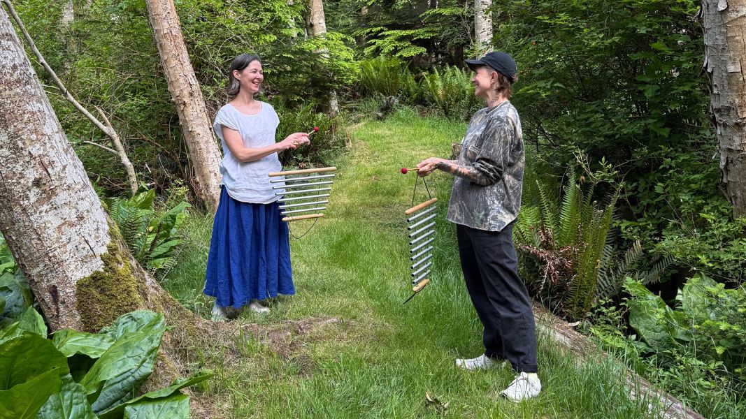 Kiko and Charlie play chimes on a forest path