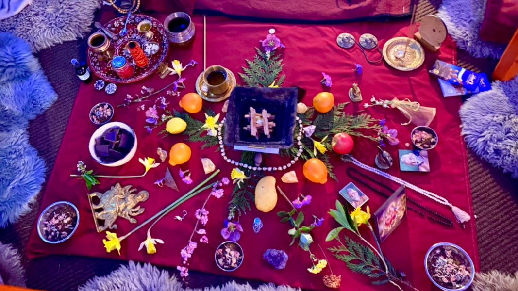 An altar of natural elements on a red cloth