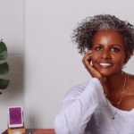 Sebene Selassie sitting at a desk resting chin in hand