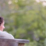 A woman resting on a railing looking into the distance
