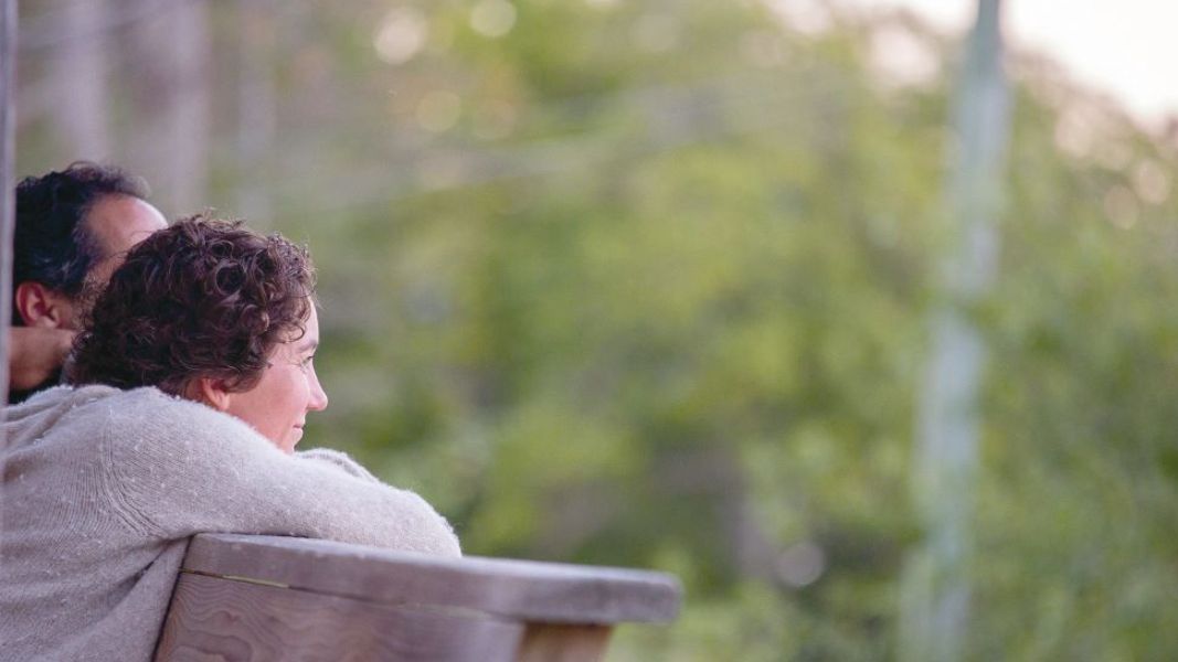 A woman resting on a railing looking into the distance